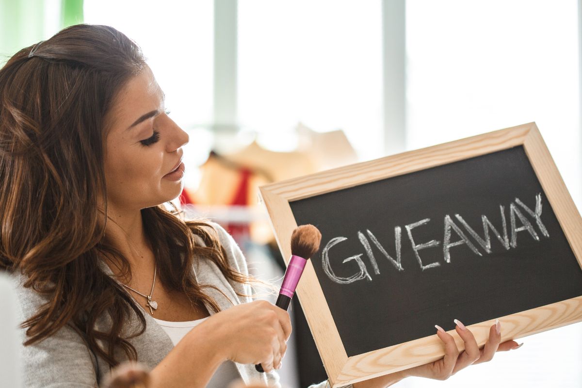 A woman holding a sign that says giveaway