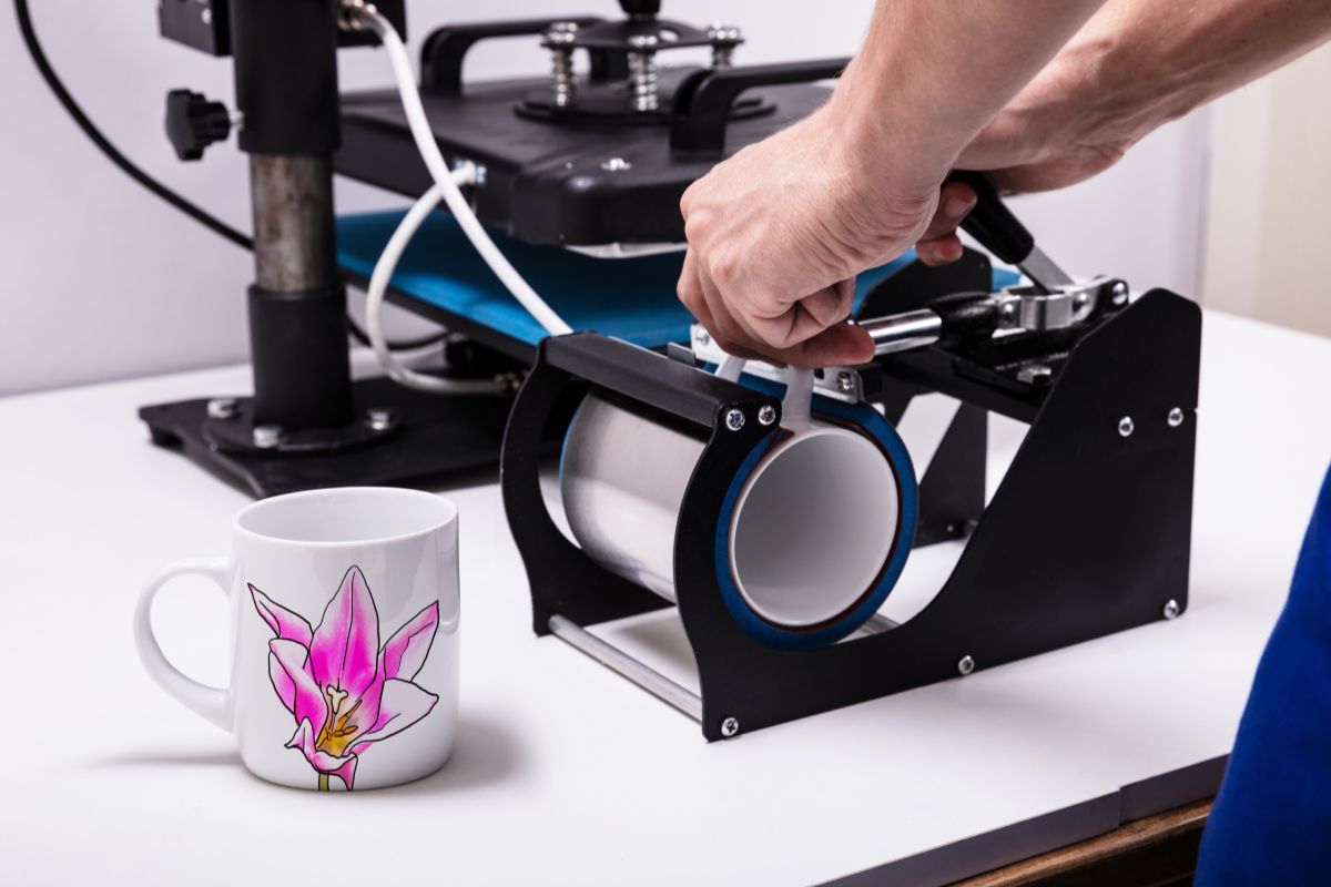 A guy sublimating on the cup by the help of sublimation printer.