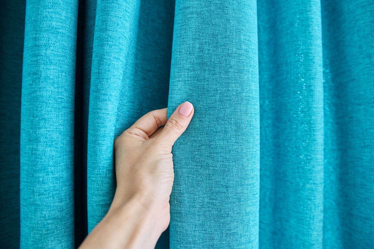 A hand touching the polyester fabric