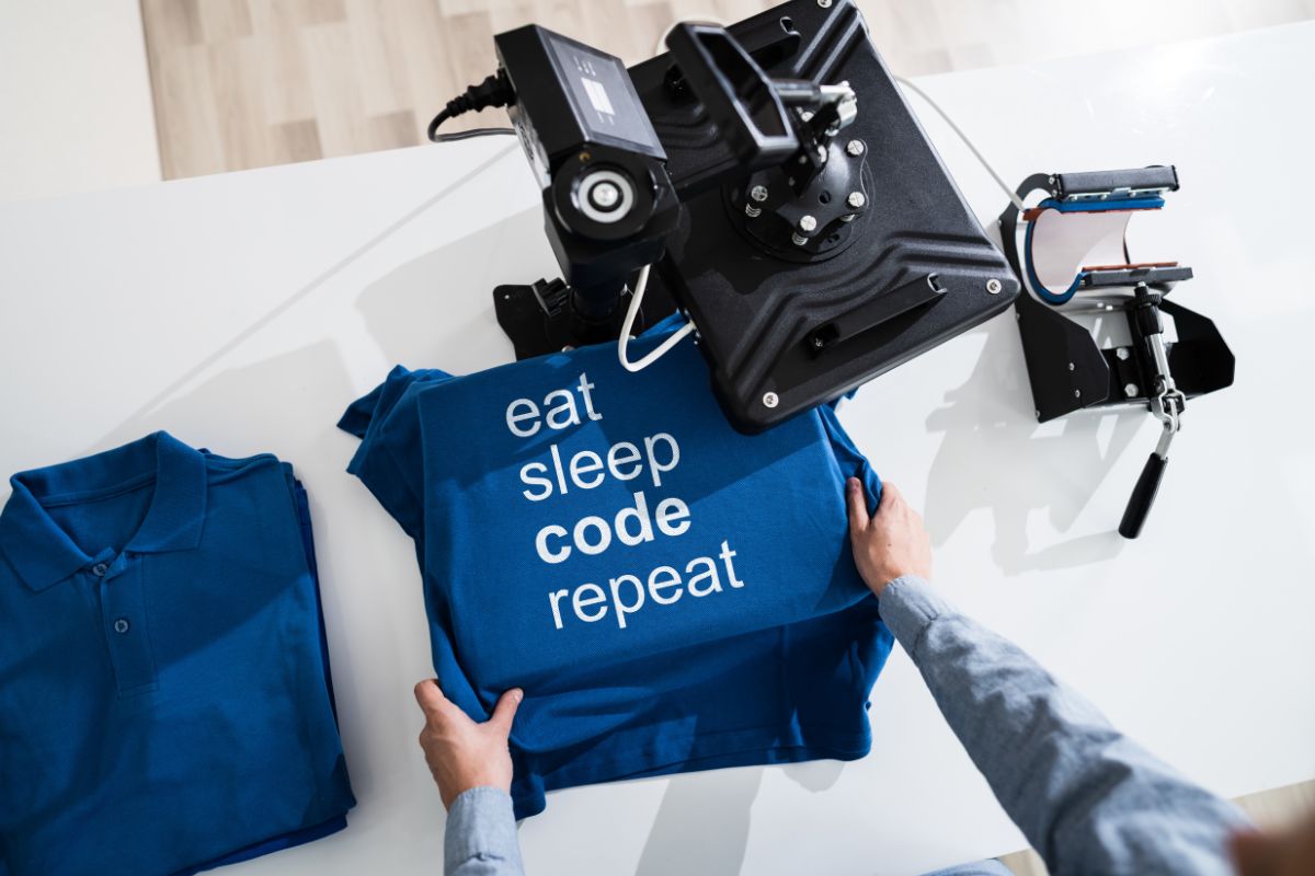 A man thinking How to start a t shirt business while holding blue T shirts