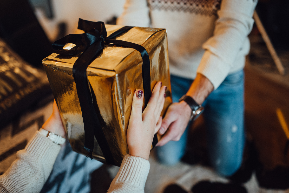 Woman handing over holiday gift to Client