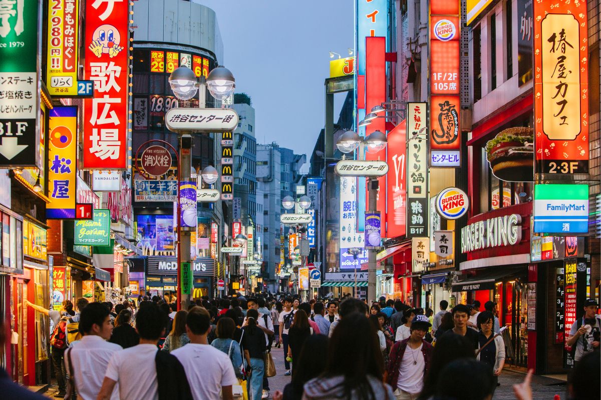 People walking through a street having multiple signage