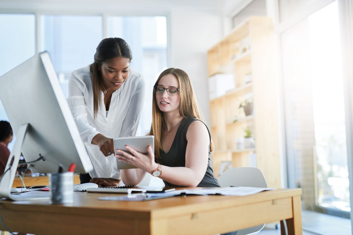 Two women strategizing for Etsy shop growth in office