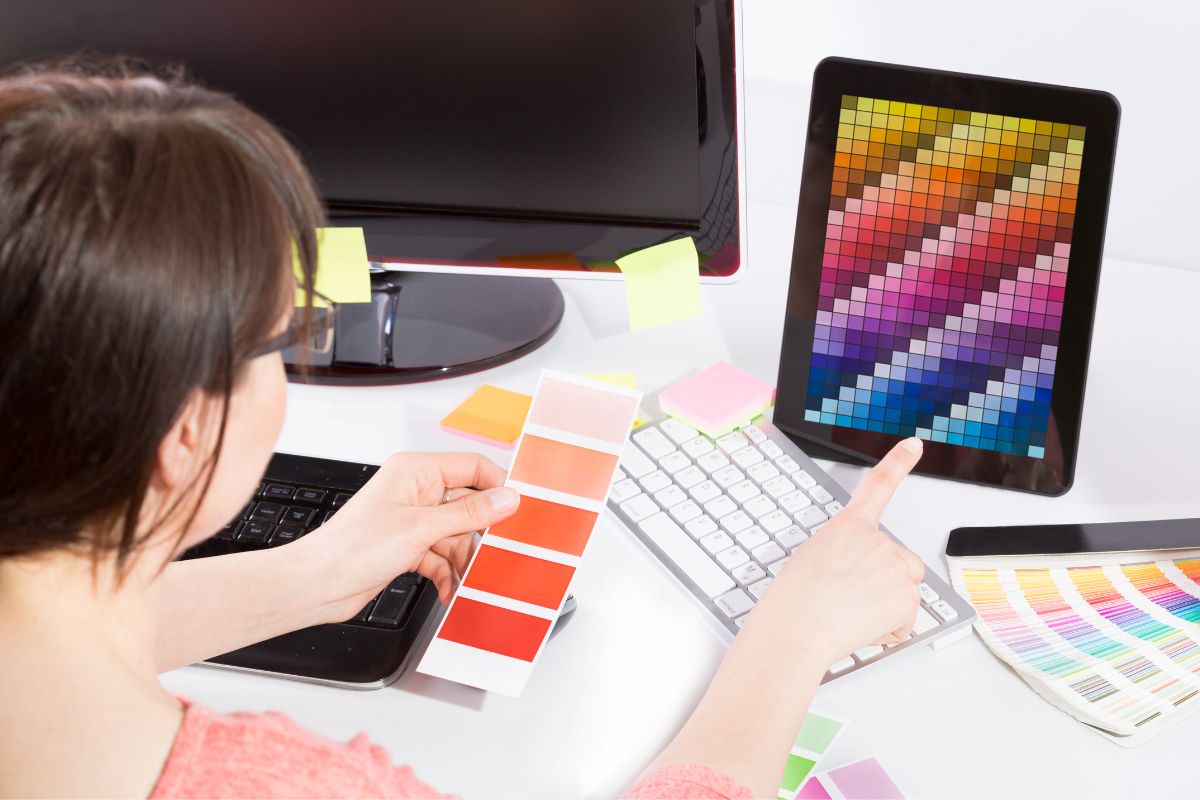 Woman choosing colors from a color chart to convert Pantone to Hex codes