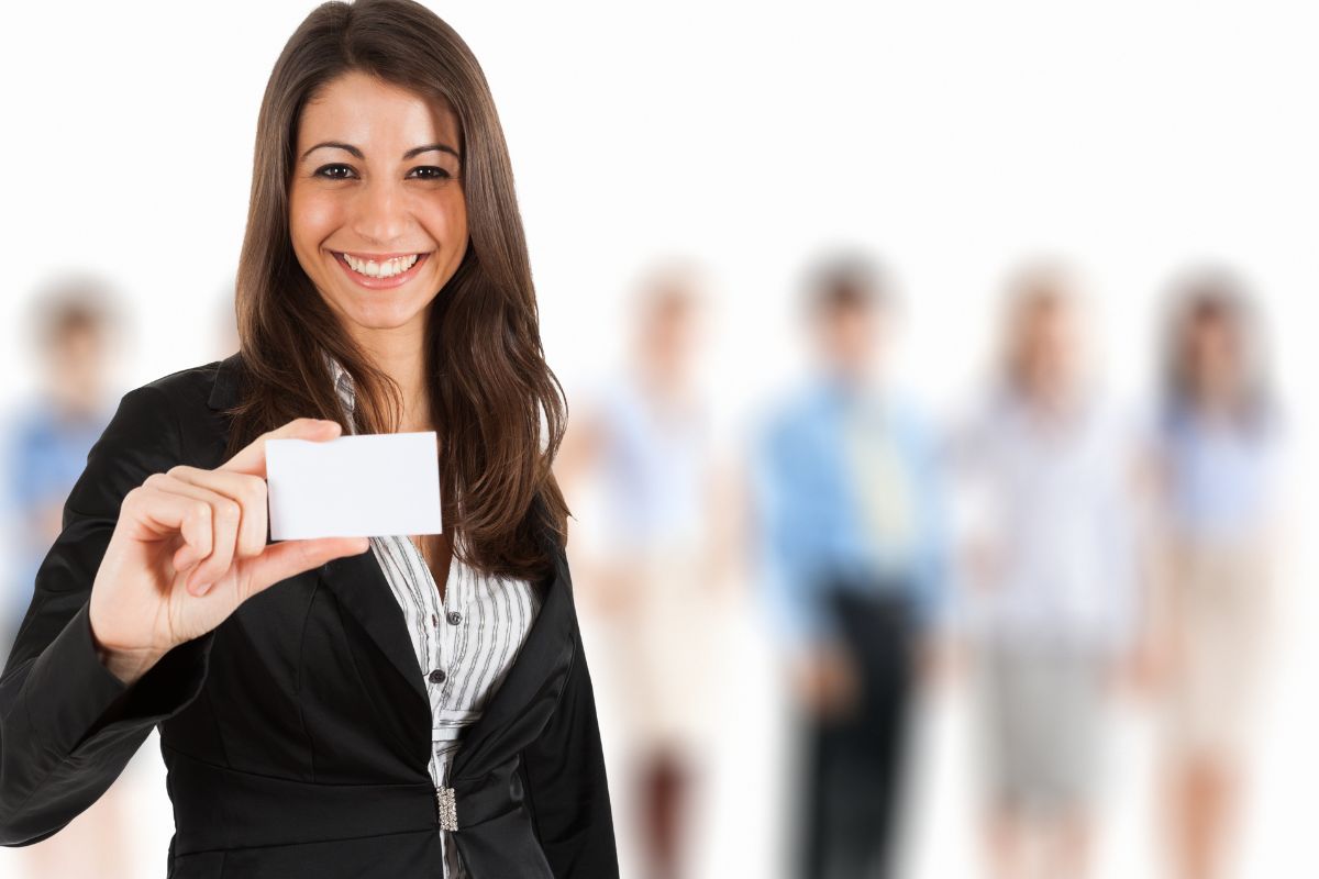 Woman holding a business card to show what to put on business card