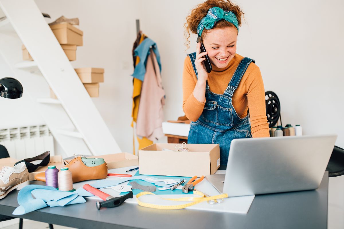 Woman with laptop talking over the mobile selling things on ebay