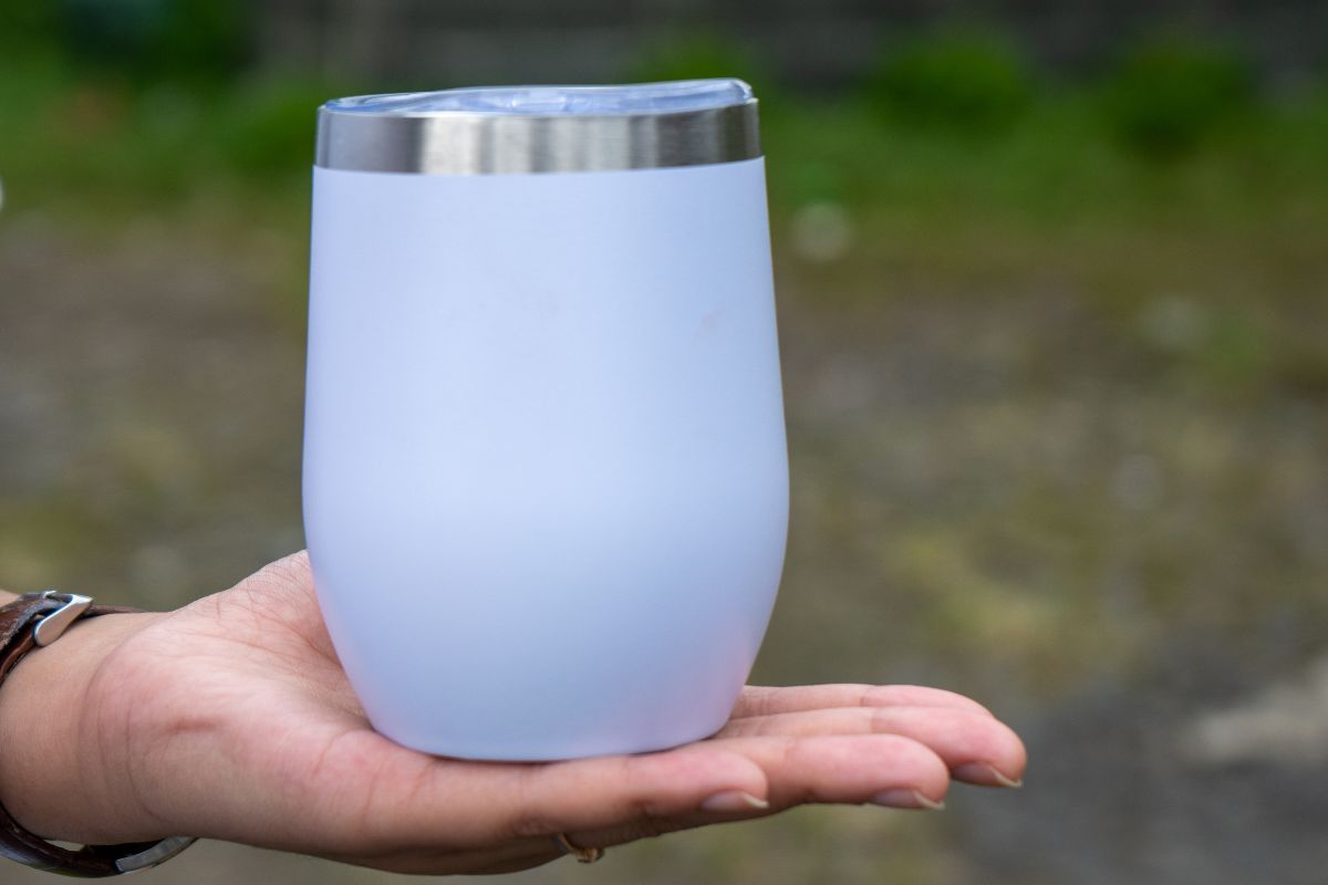 A ceramic tumbler placed on the hand