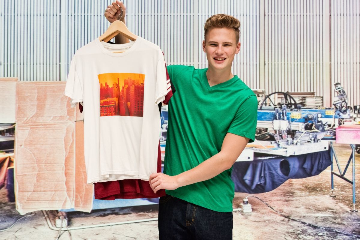 A guy displaying printed t shirts made with the best fabric