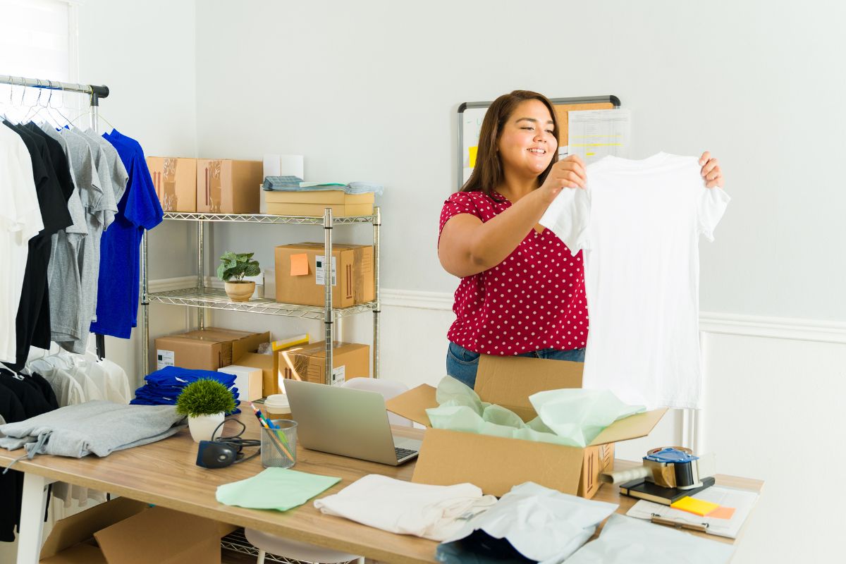 A woman displays a t shirt for a print on demand business