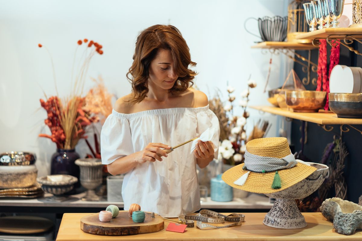 A woman is considering the idea of designing hats