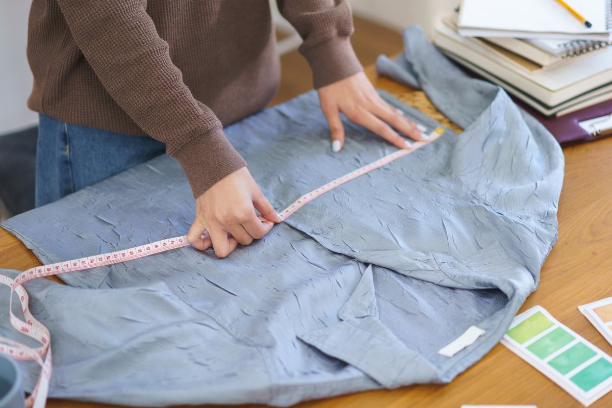 A woman is measuring shirt size using a tape measure
