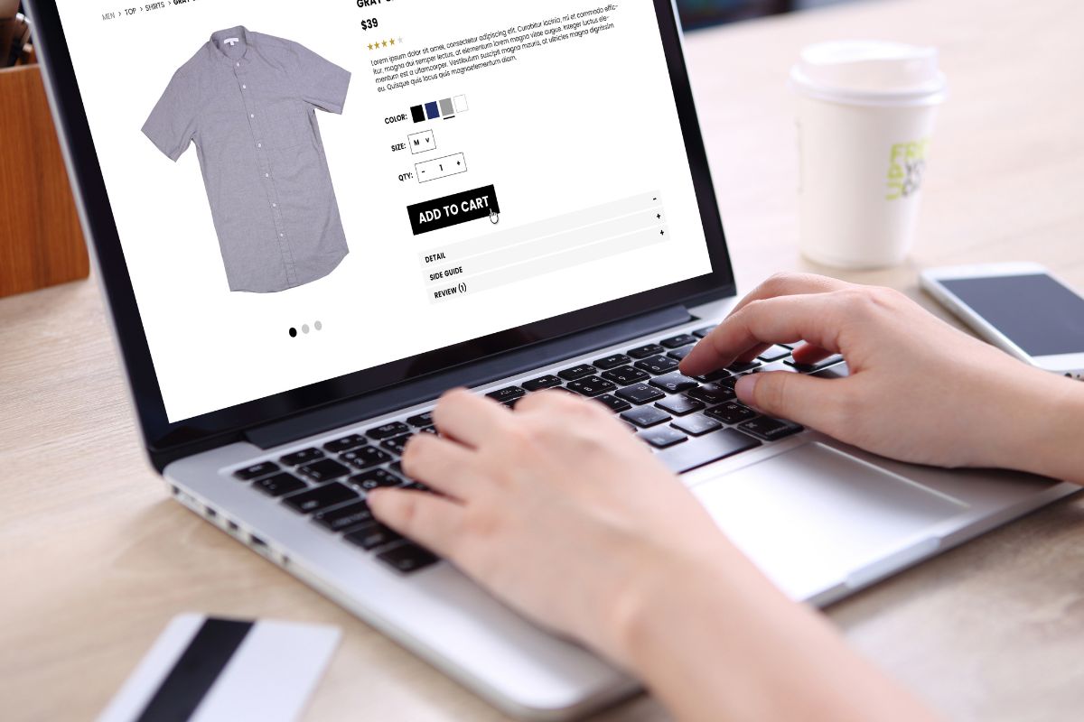A woman sat with her laptop browsing online for the perfect shirt to add to her cart