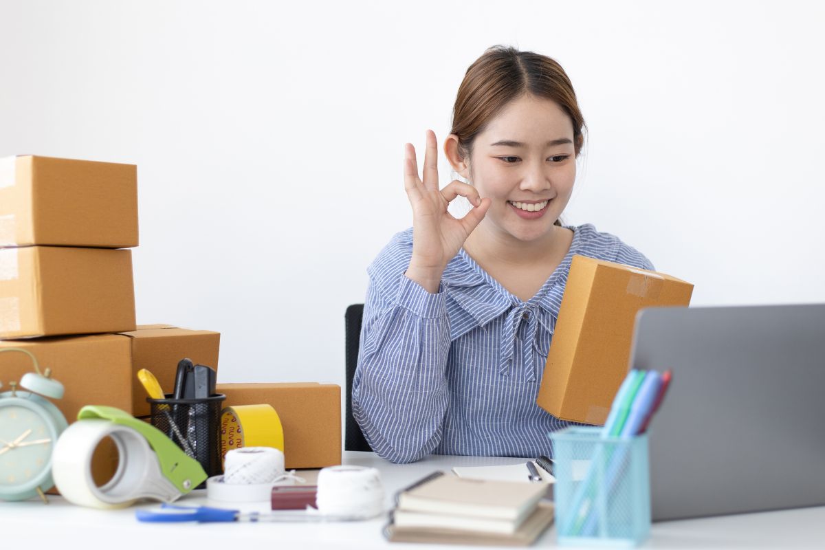 A woman sitting in front of a laptop promoting branded dropshipping products