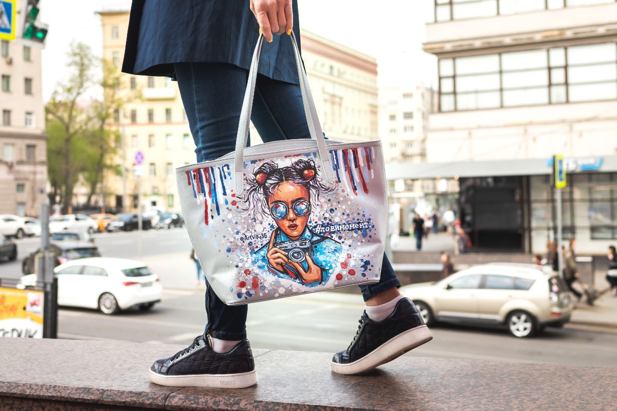 A woman walks while holding print on demand tote bags