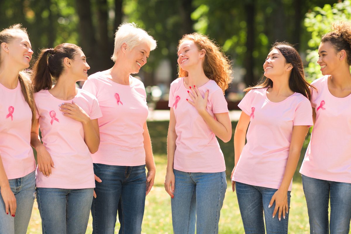 Smiling women organising event for breast cancer awareness