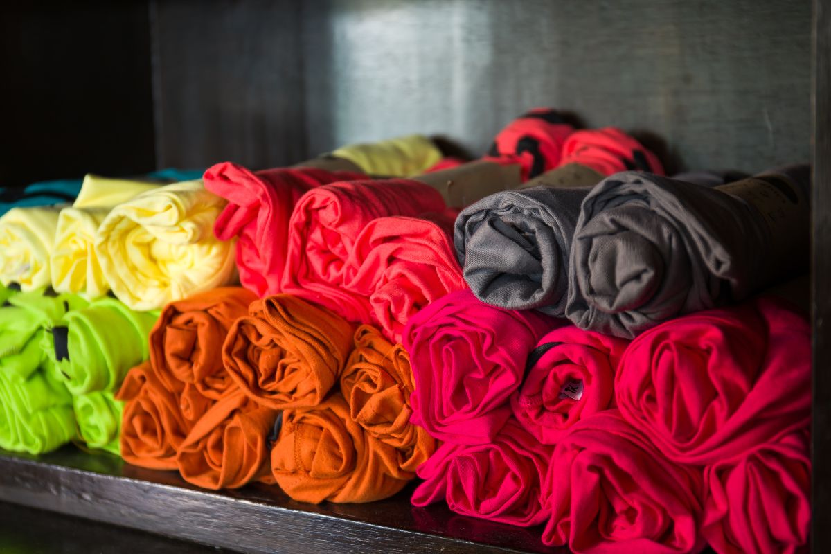 Various rolled cotton t shirts displayed on a table