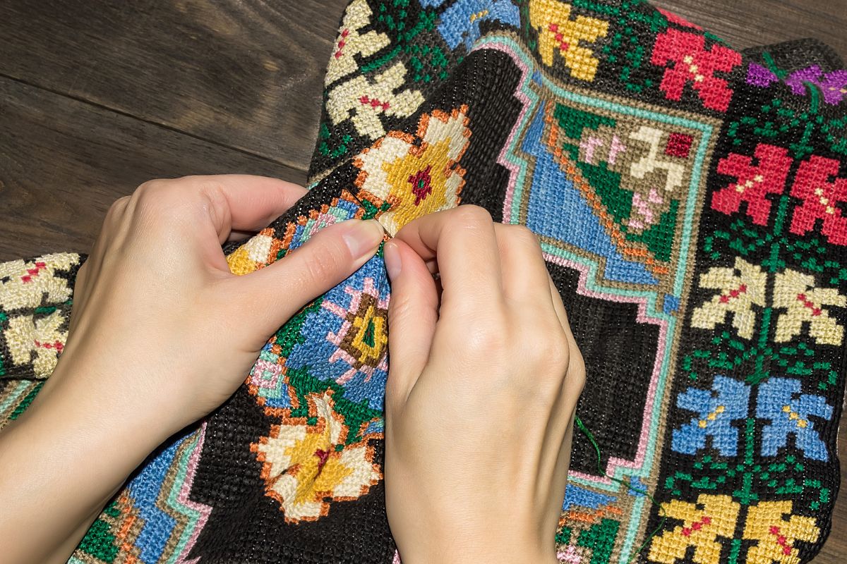 Woman is doing Embroidery work on canvas