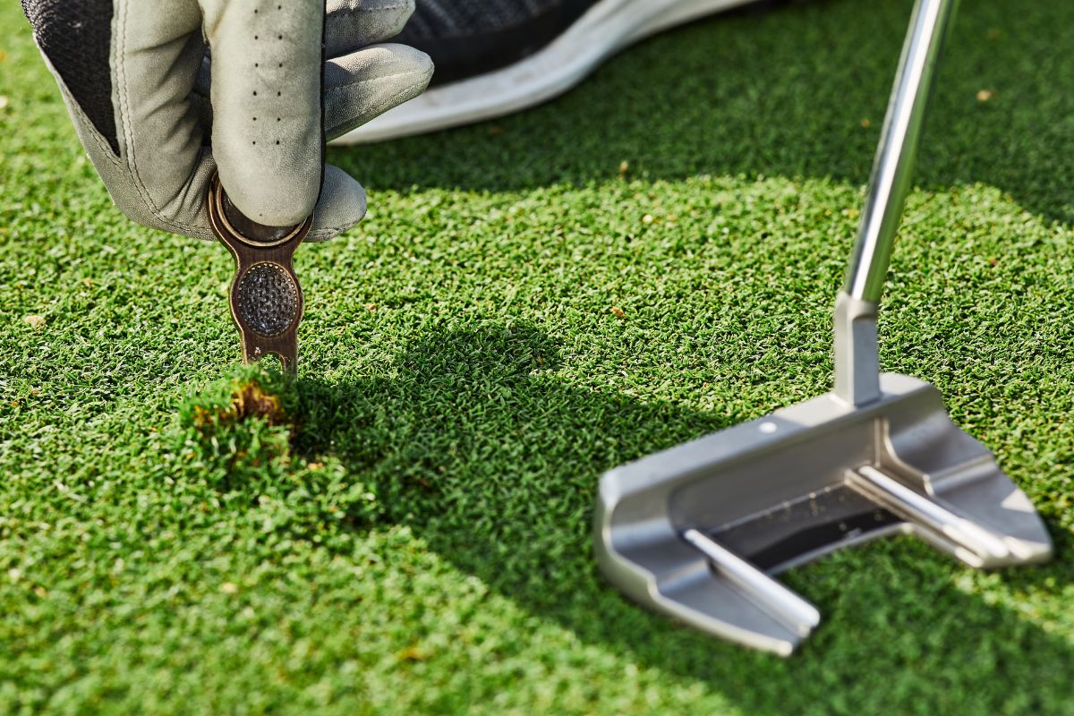 A close up view of Divot repair tool used by golfer