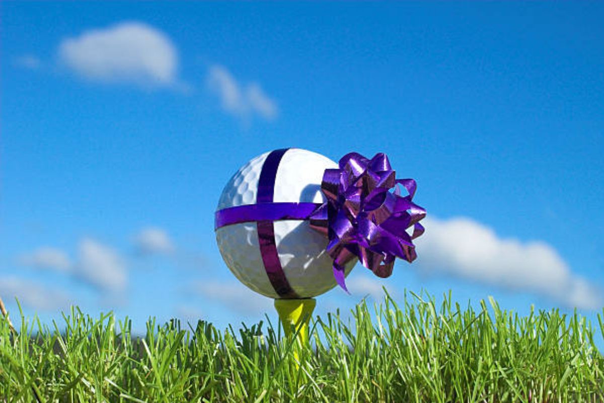 A golf ball wrapped as a gift depicting a swag gift ideas for golfer.