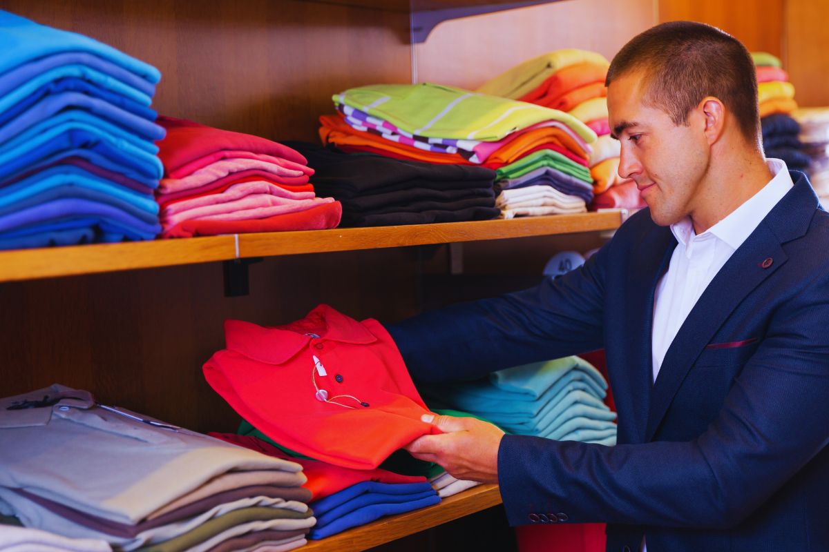 A guy looking at the final product of custom polo shirt