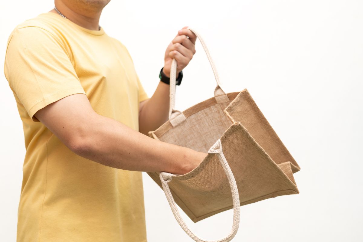 A guy showing ecofriendly bag which he received from the office