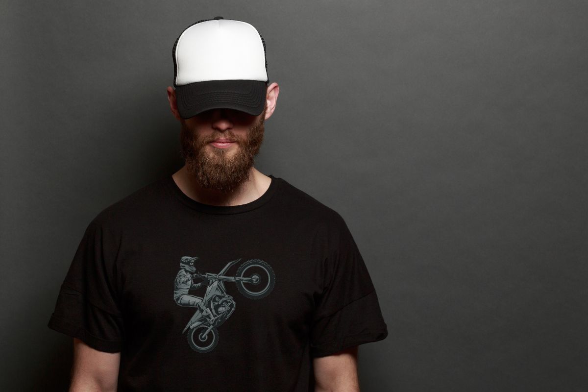 A guy wearing a black biker t shirt and a cap