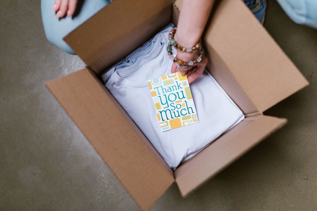 A lady receiving t shirt order with a message from the dealer.