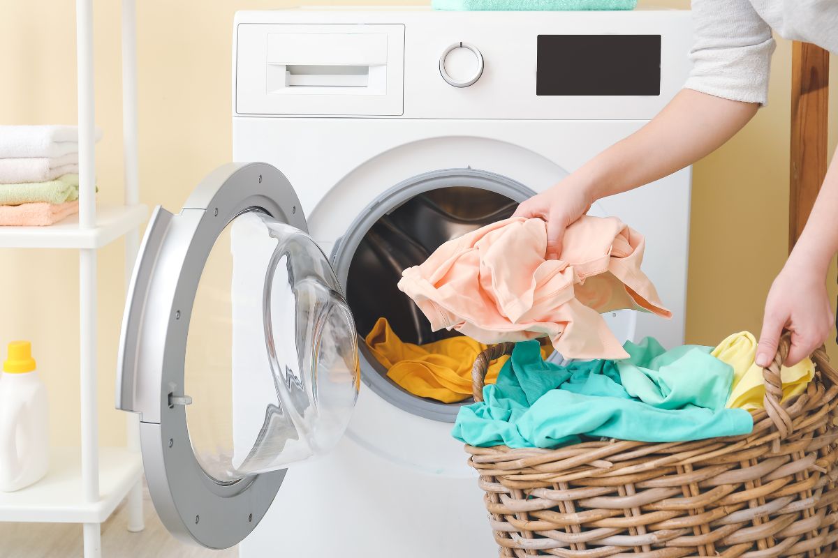 A lady washing polyester cloth in a washing machine