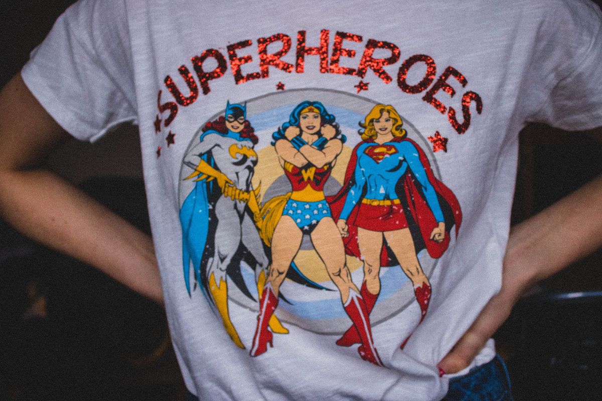 A lady wearing t shirt on which super heroines are printed