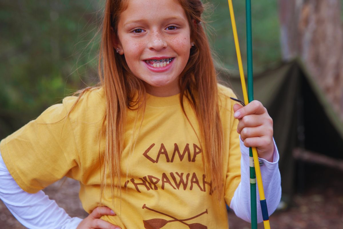 A little girl wearing camp t shirt