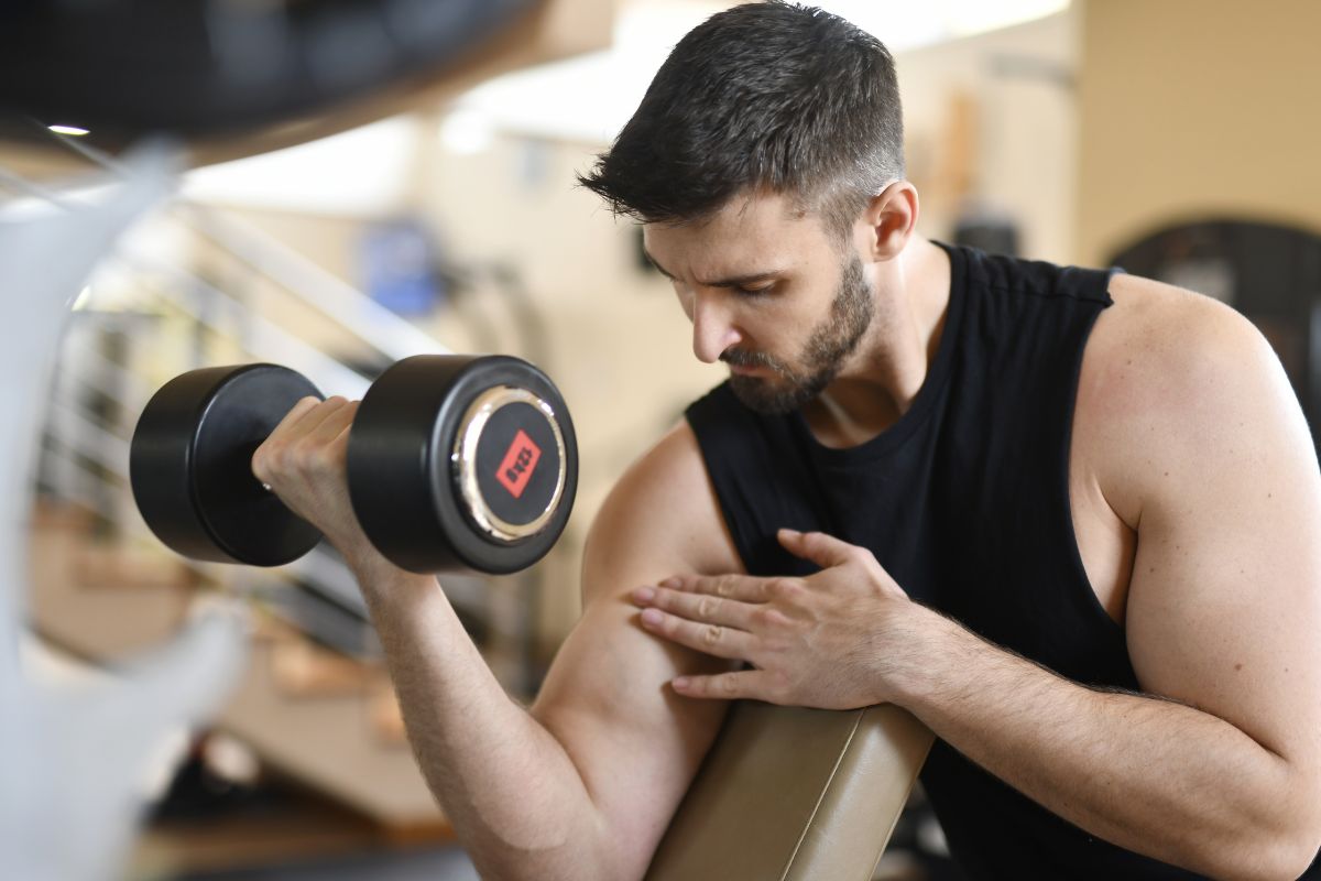 A man working out wearing a muscle tank top