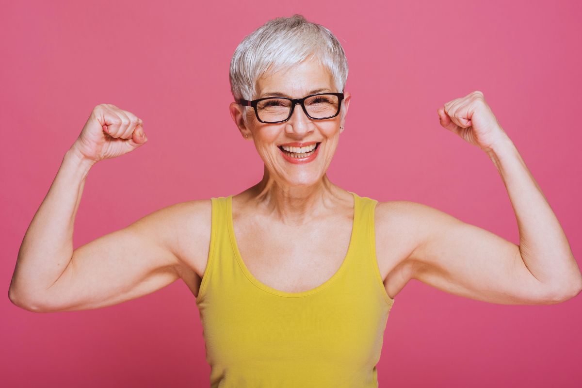 A woman is very happy wearing a yellow coloured muscle tank top