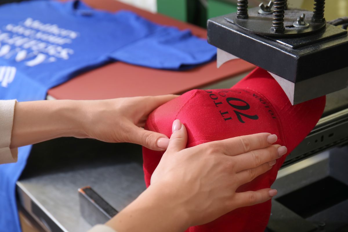 A women doing direct to garment printing on hat