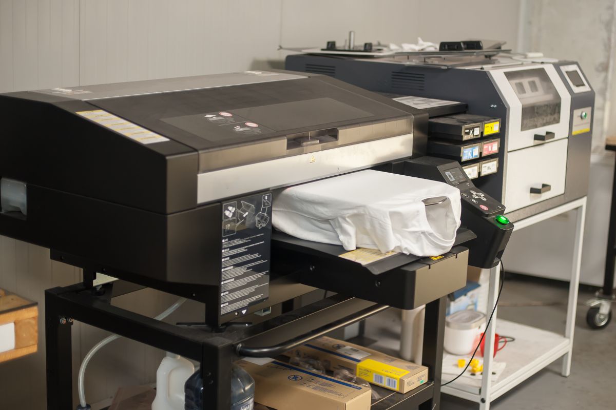 Digital t shirt printing heat press machine in printing production shop.