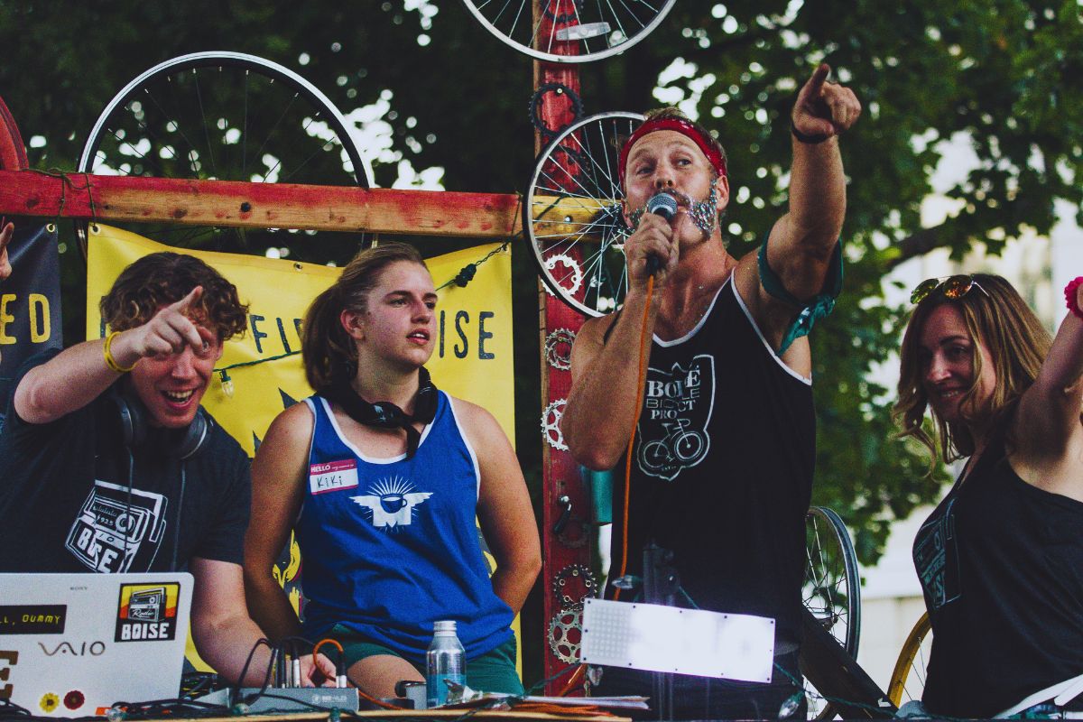 Four Guys Wearing Blue and Black Muscle Tank Tops at an Event