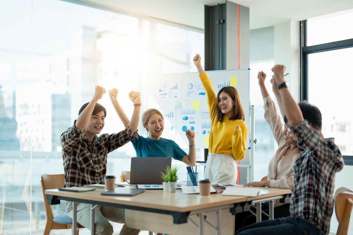 Newly hired employees celebrating project success.