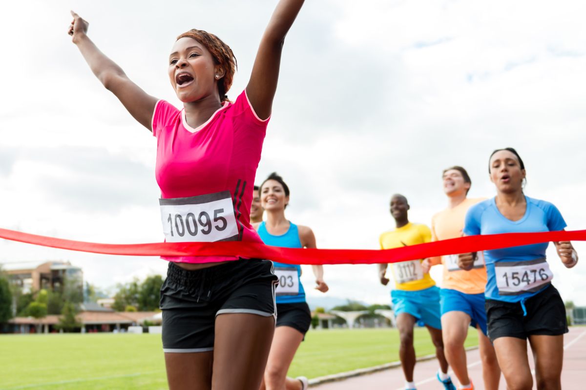 Women participating in a running sport with numbers attached to their t shirts