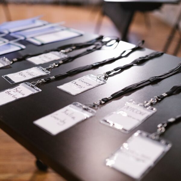 A collection of lanyards with ID attached to them kept on a table for corporate event