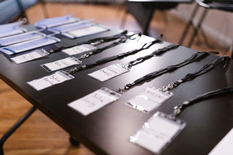 A collection of lanyards with ID attached to them kept on a table for corporate event