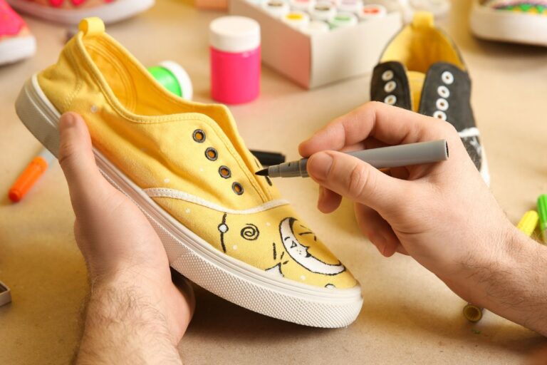 A person customizing his shoes by adding designs to it