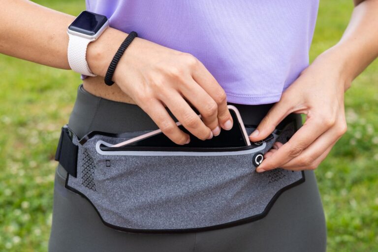 A lady is putting her phone in her custom fanny pack
