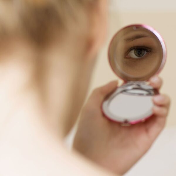 A lady watching herself on the custom mirror