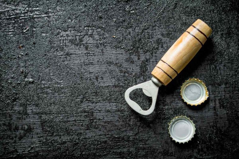 A wooden bottle opener kept with bottle caps