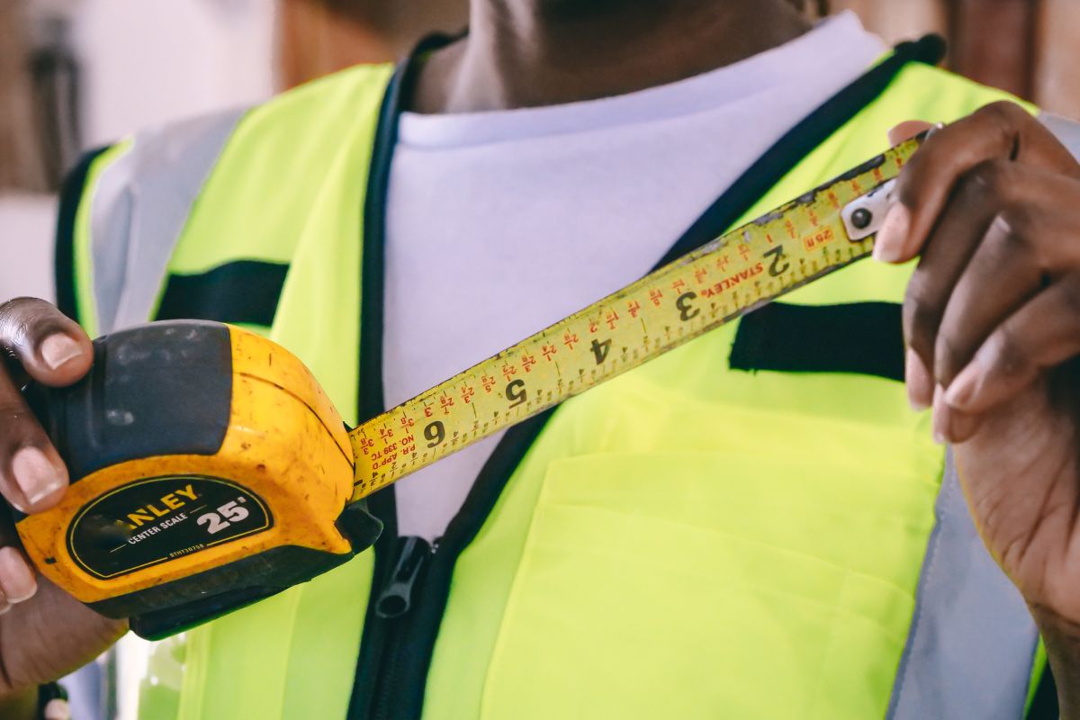 A construction worker is using a custom tape measure