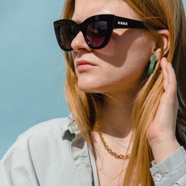 A lady wearing custom sunglasses with her name printed on it