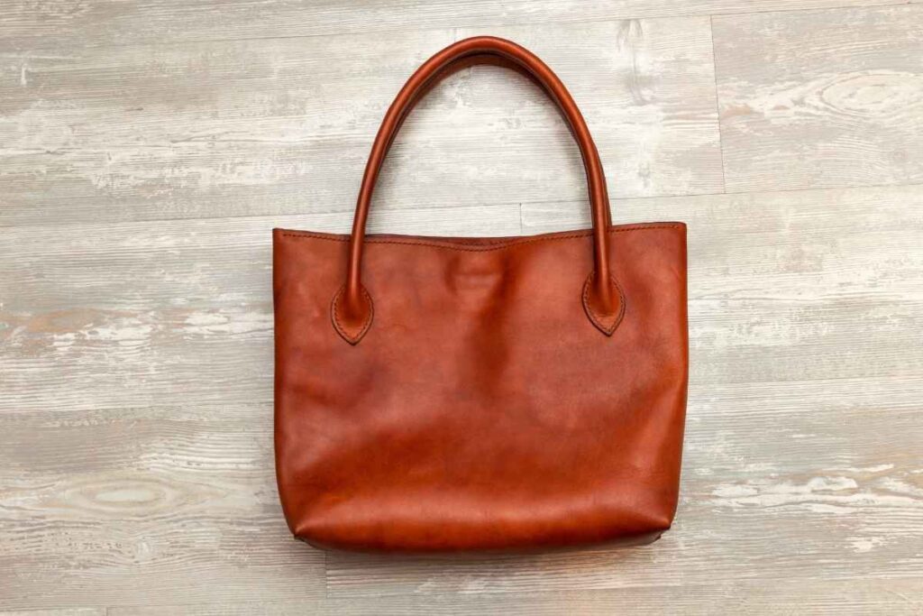A custom leather tote bag is shown in the image