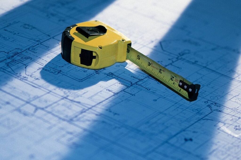 A custom tape measure lying on a blueprint
