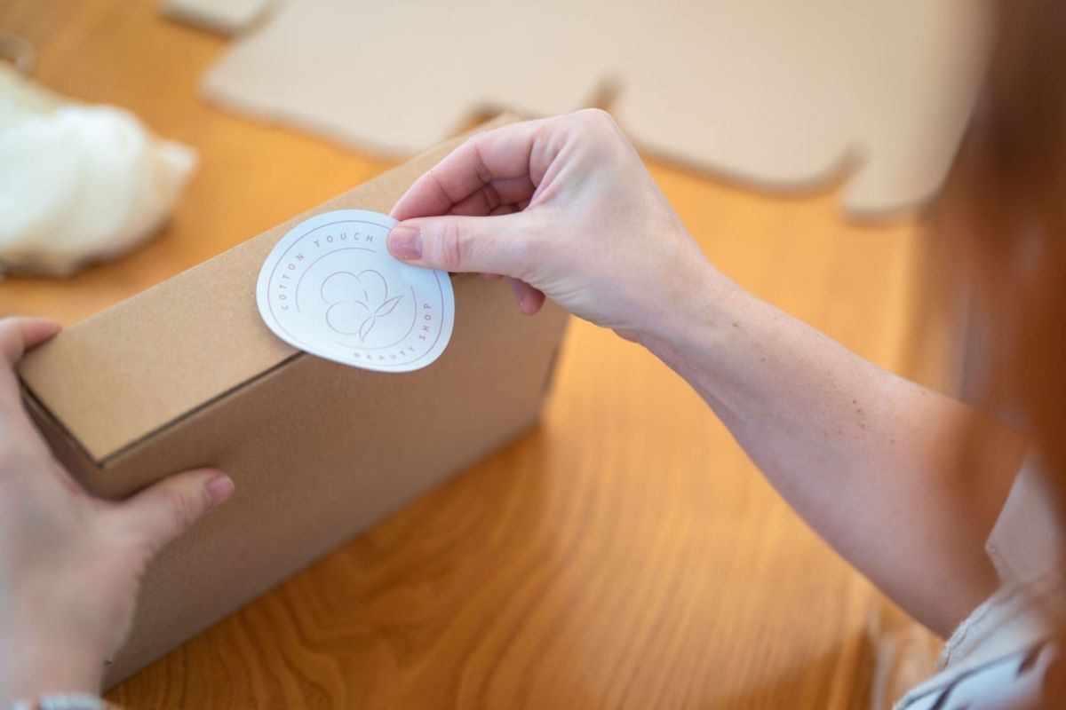 A lady applying custom stickers to her products