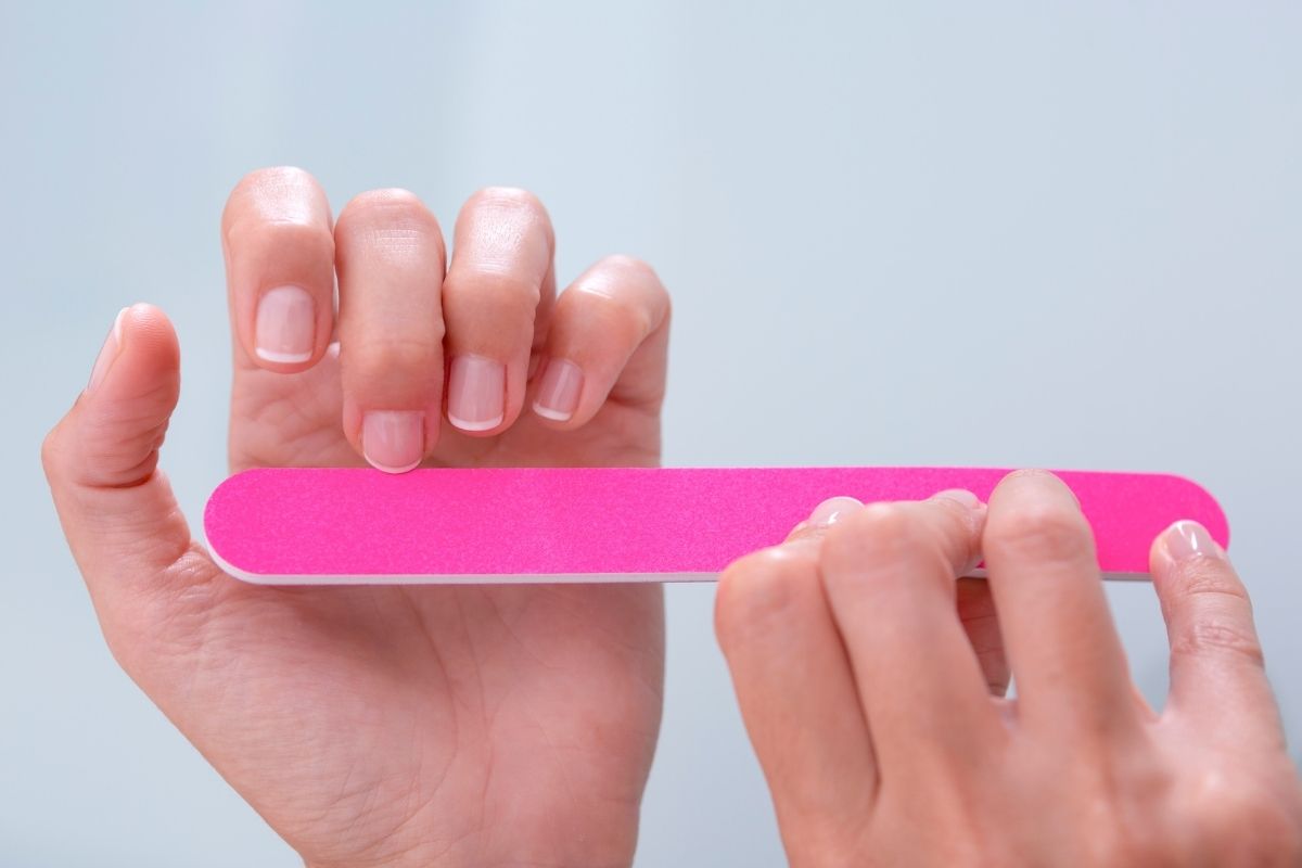 A lady using a glass nail file