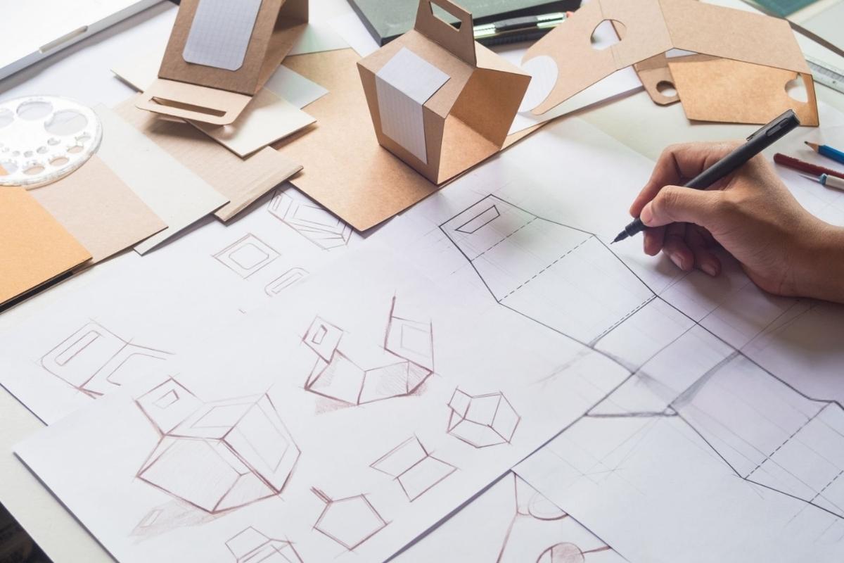 A person designing a custom packaging box